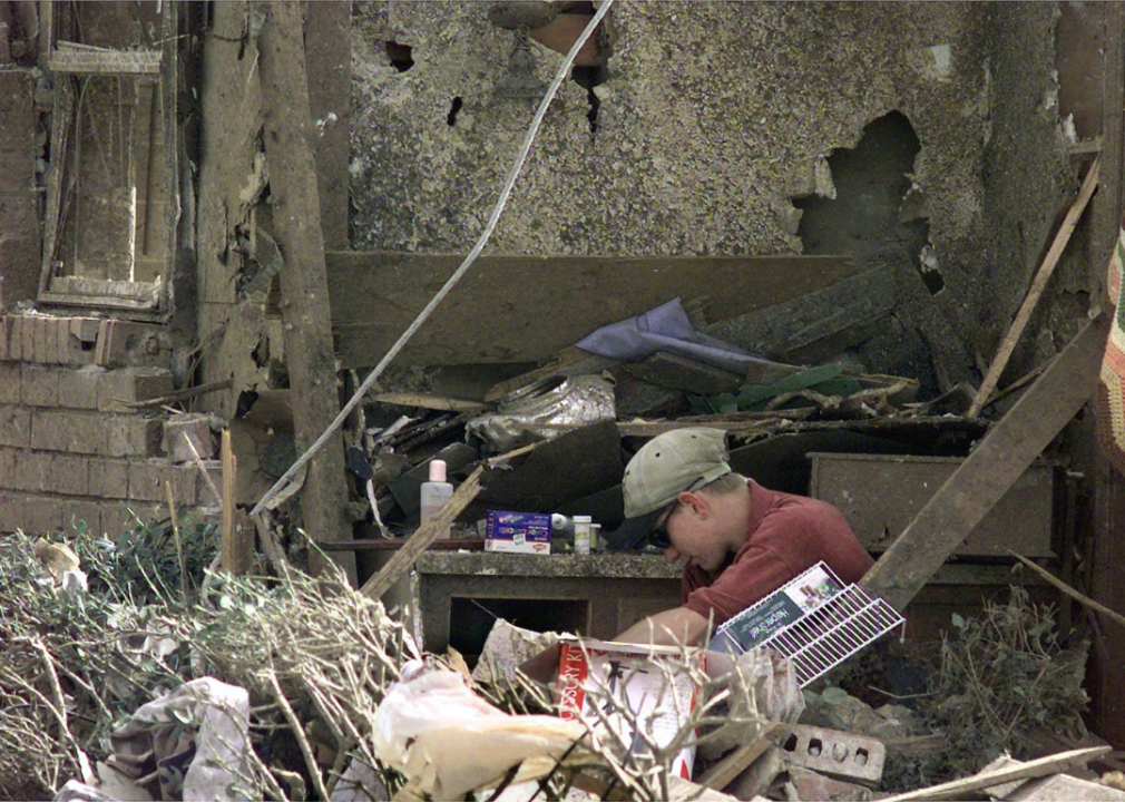 A teenager looks through the remains of his family residence after a tornado.