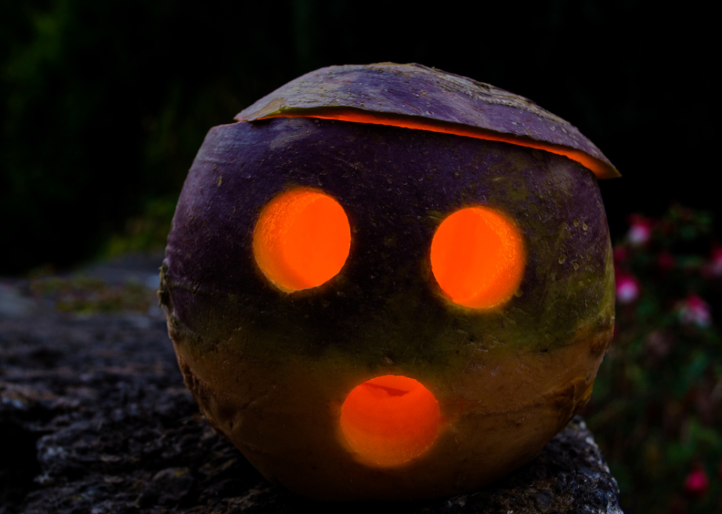 A closeup of a jack-o'-lantern made of turnip.