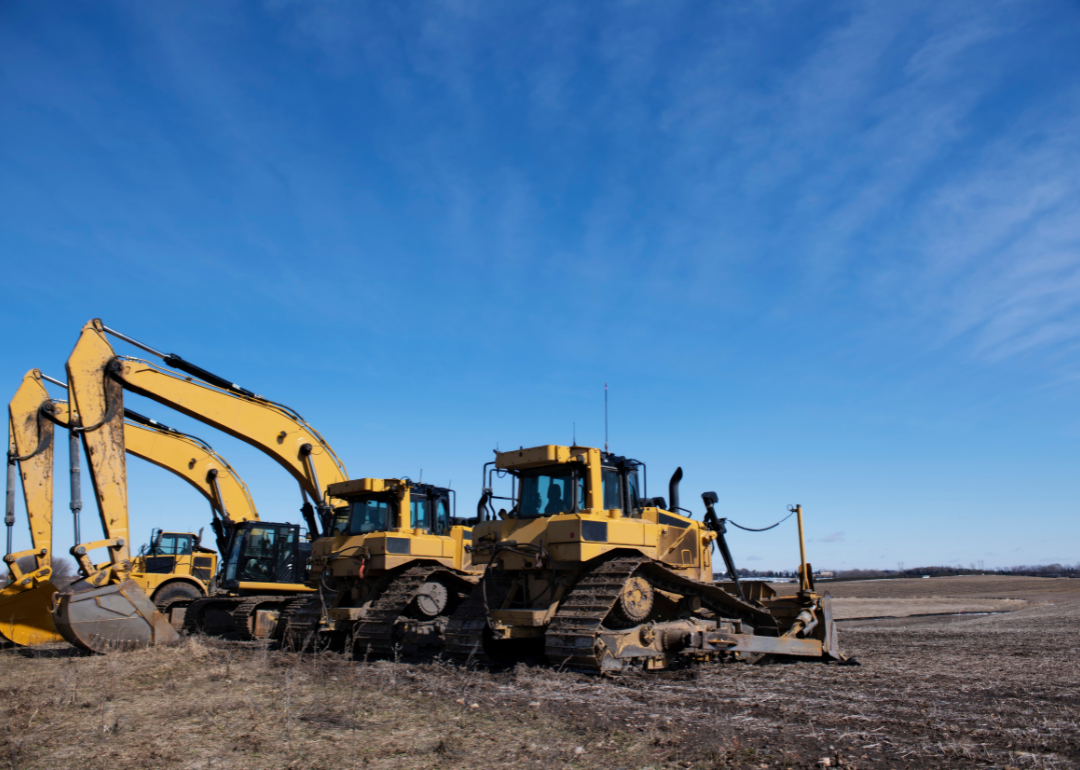 Heavy construction equipment in front of a blue sky.