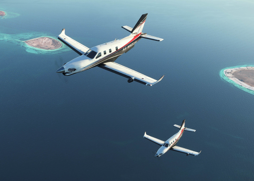 Two planes flying over water in "Microsoft Flight Simulator."