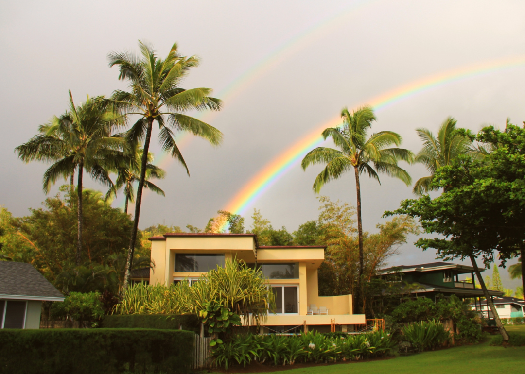 A home in Kauai, Hawaii, with a double rainbow above it.