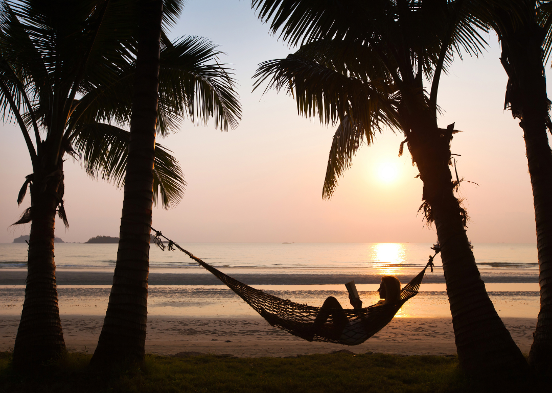 A person in a hammock by the beach.