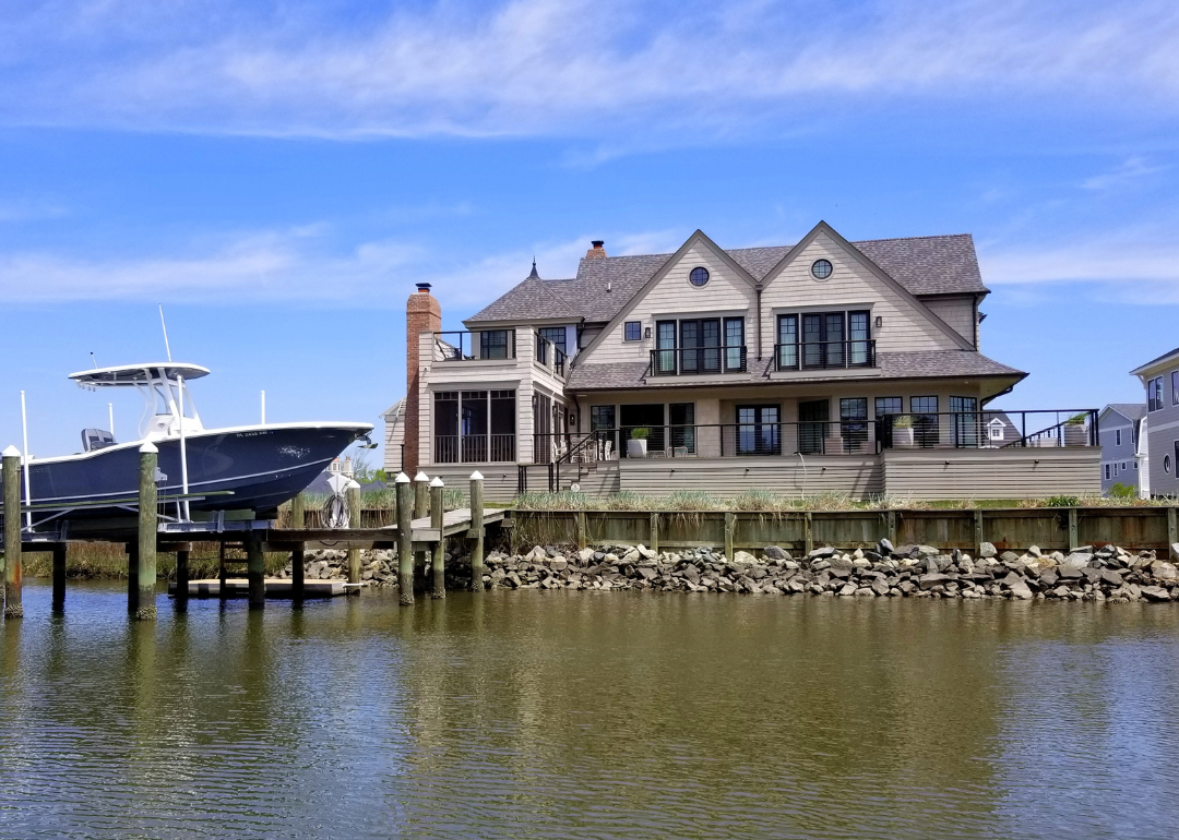 Luxury, new construction waterfront homes with a boat docked by the bay in Rehoboth Beach.