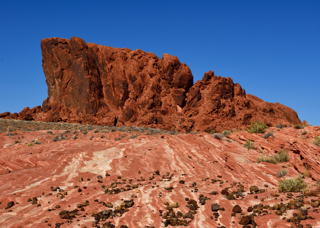 A red-orange rock formation in a Nevada desert.