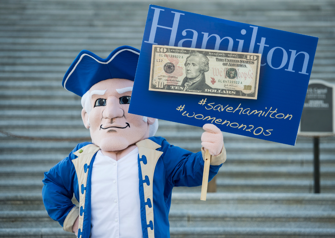 Hamilton College mascot "Alex" aka Alexander Hamilton posing with a sign.
