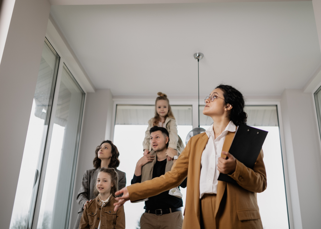 A real estate agent showing a family a home.