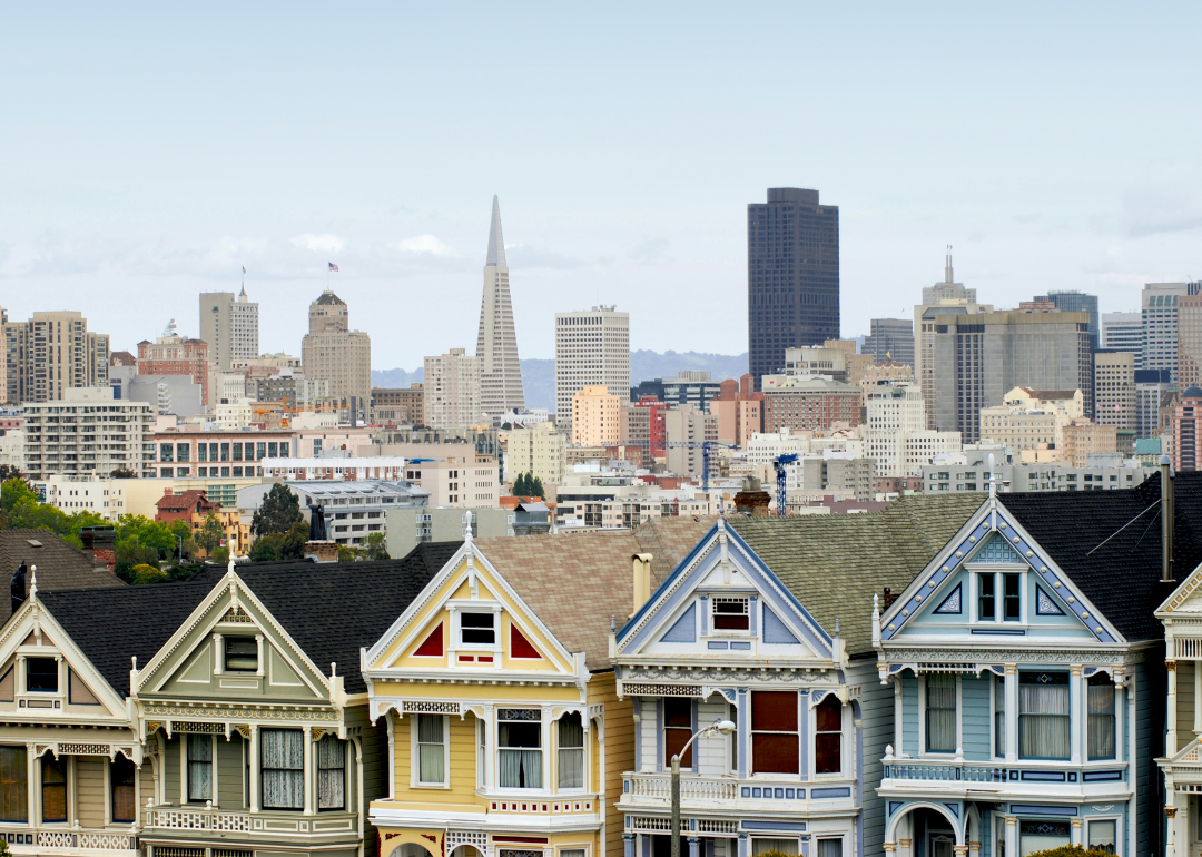 A row of homes with the San Francisco skyline in the background.