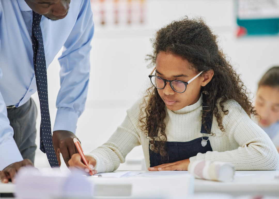 A teacher helping with a student assessment