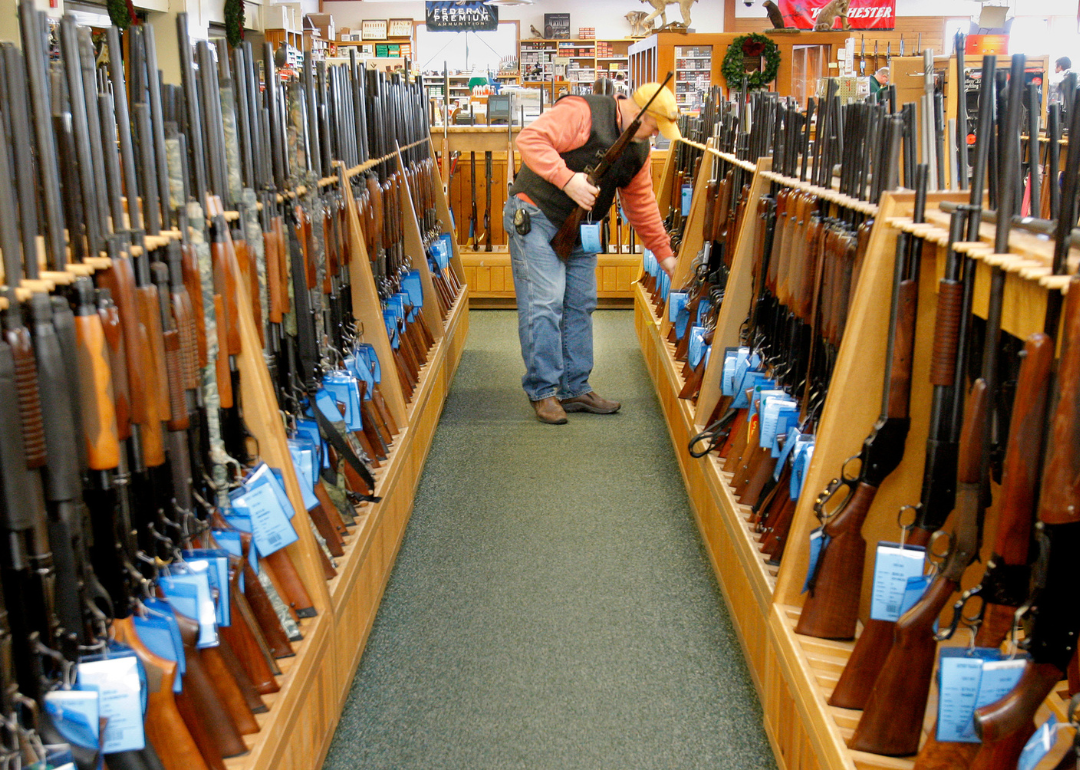 A customer looking over hunting rifles at Kittery Trading Post.