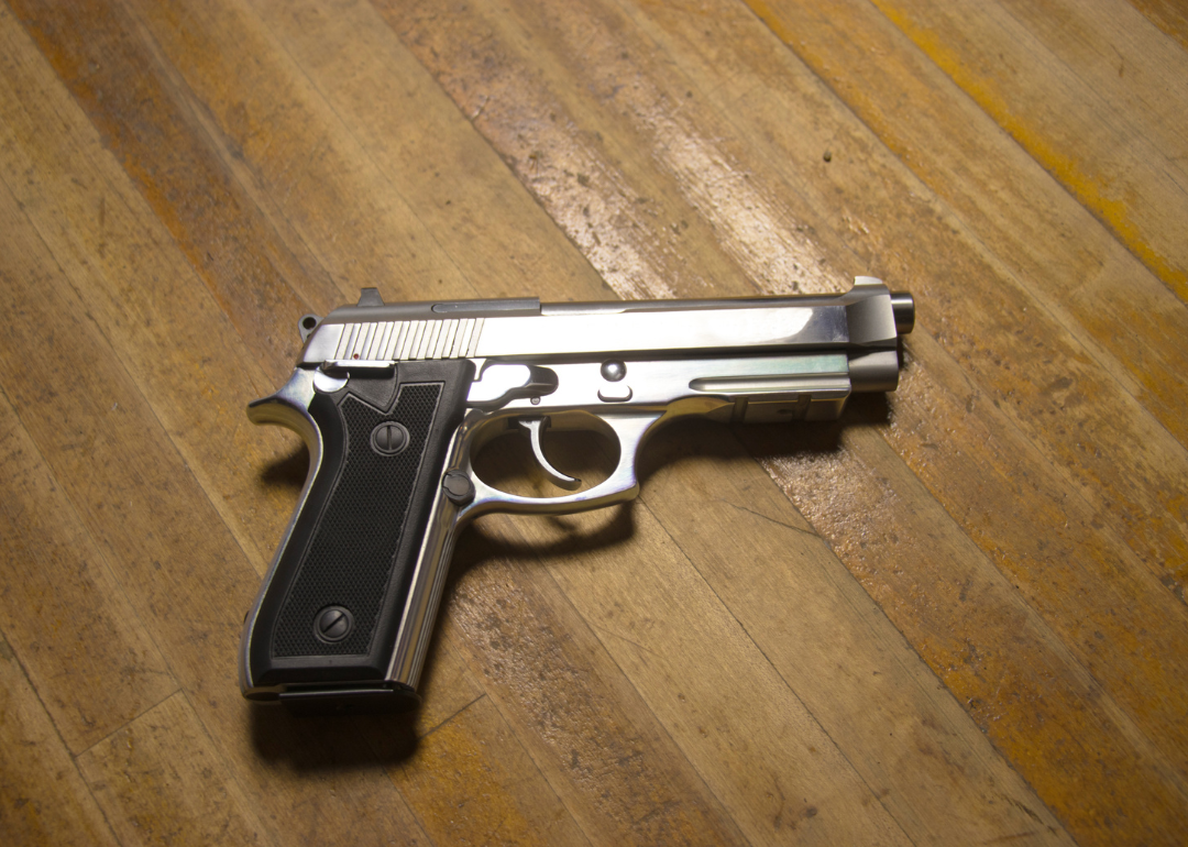 A semi-automatic pistol with a wood background in Walnut.