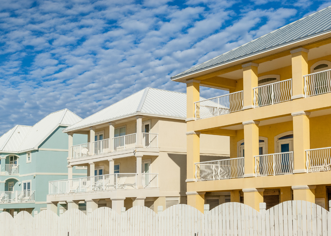 New construction oceanfront multicolored vacation homes on the white sandy beach of Gulf of Mexico in Alabama.