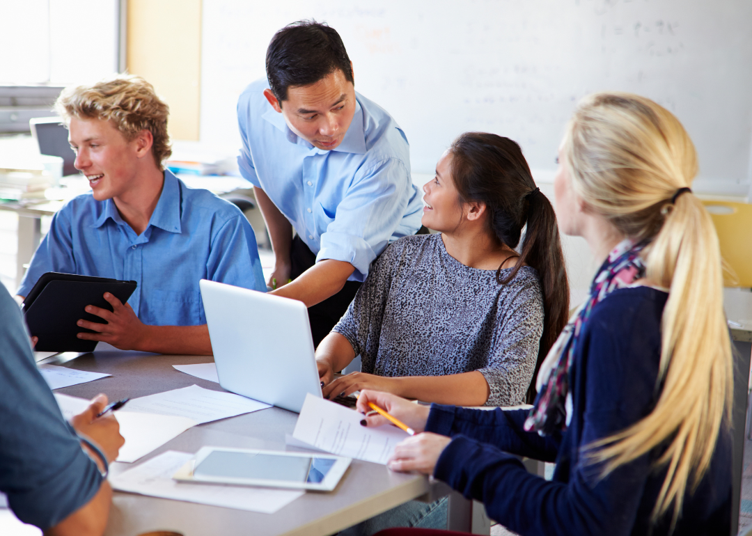 A teacher tutoring a group of four students.