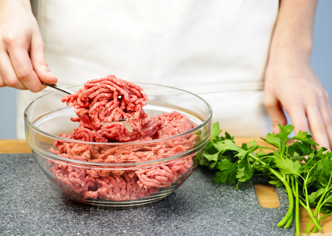 A person preparing lean ground beef in a kitchen