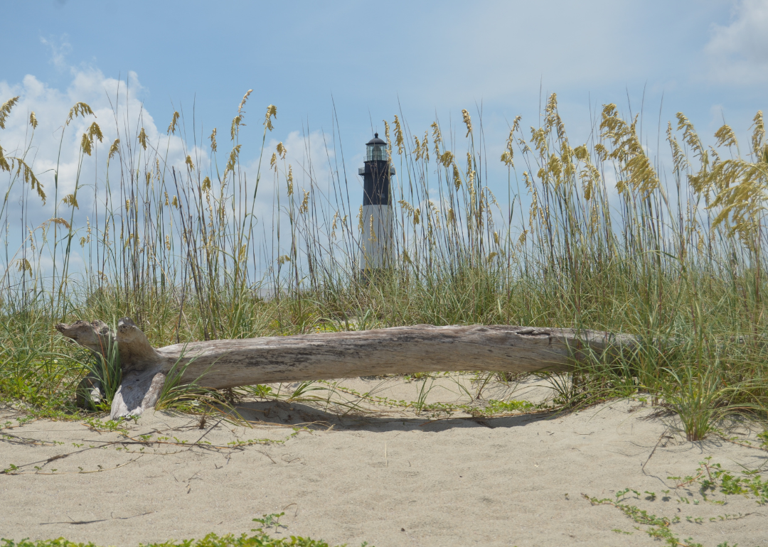 A Georgia beach with a lighthouse in the background on a summer day.