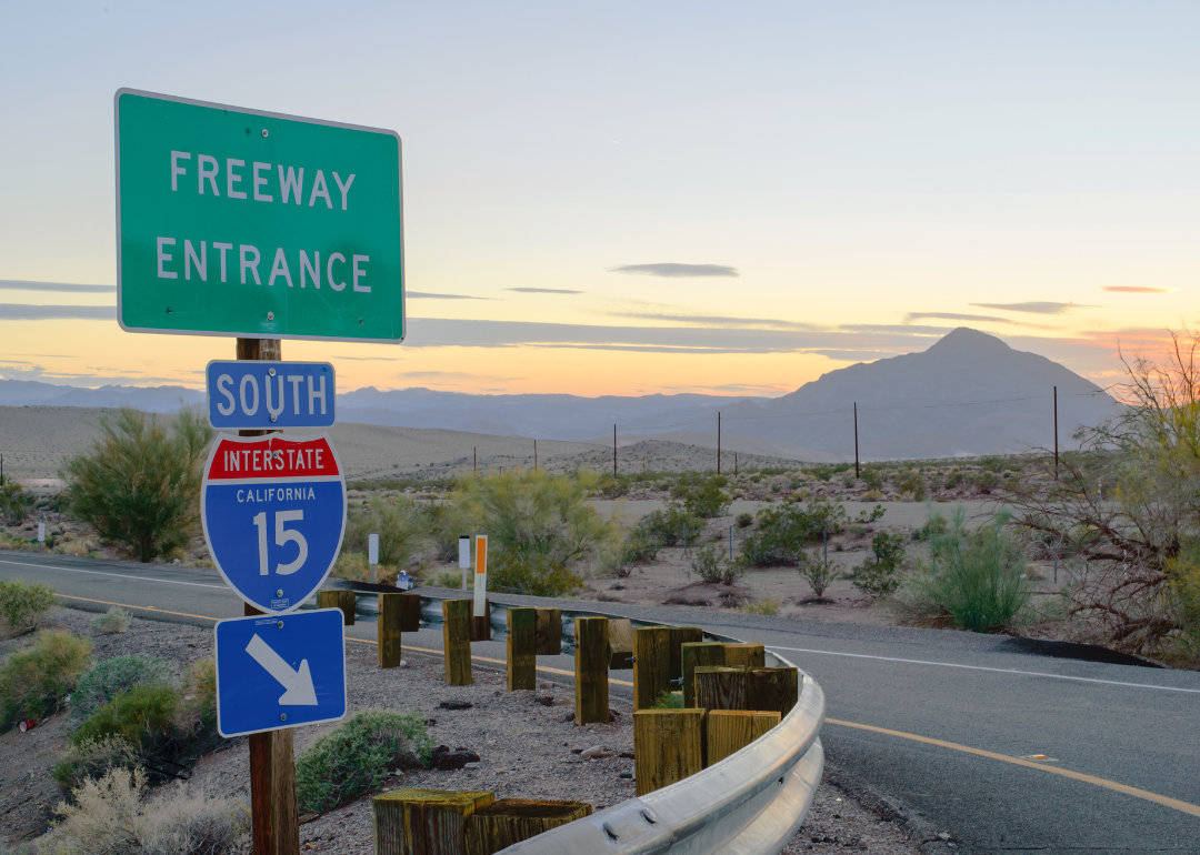 A colorful western sunset at a freeway entrance to Interstate 15 in Death Valley, California.