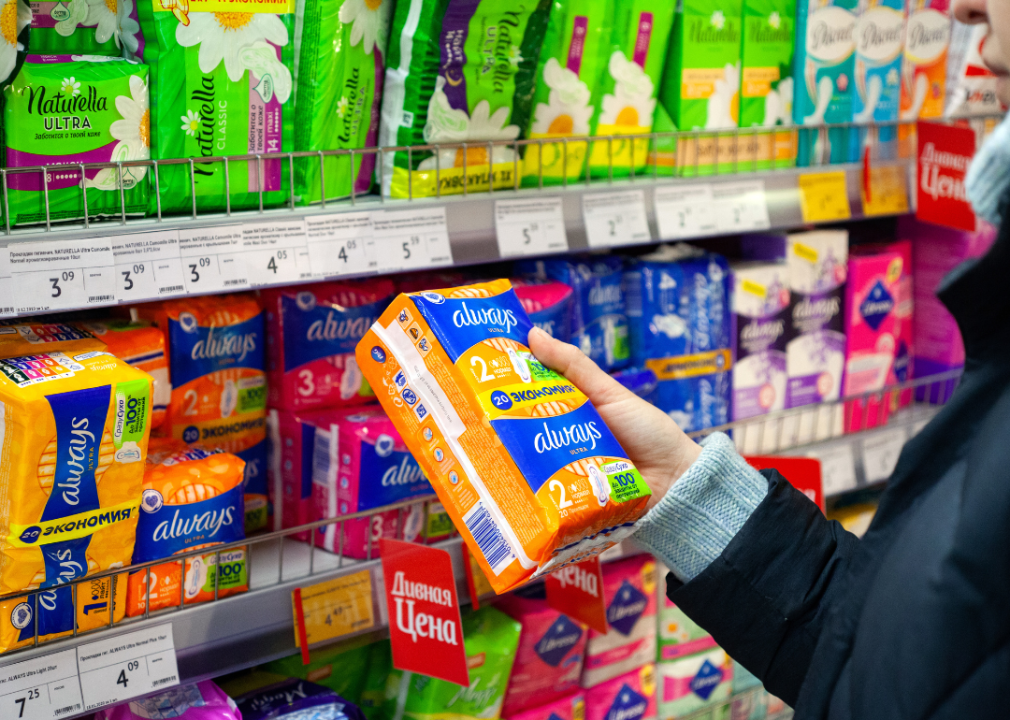 A woman choosing tampons at a store