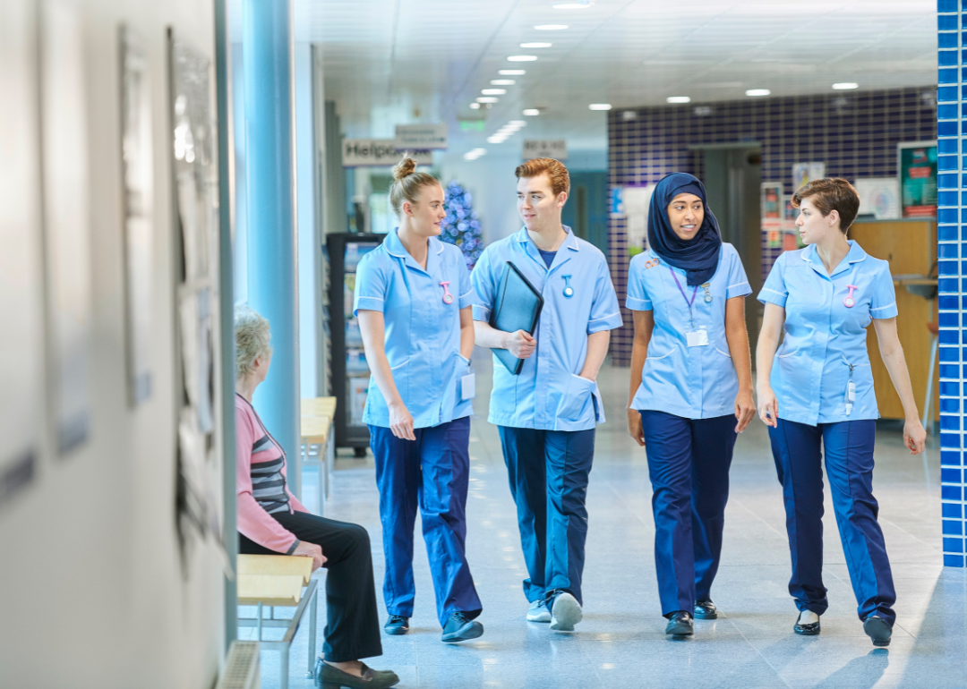 A trainee nurse team walking down a hallway.