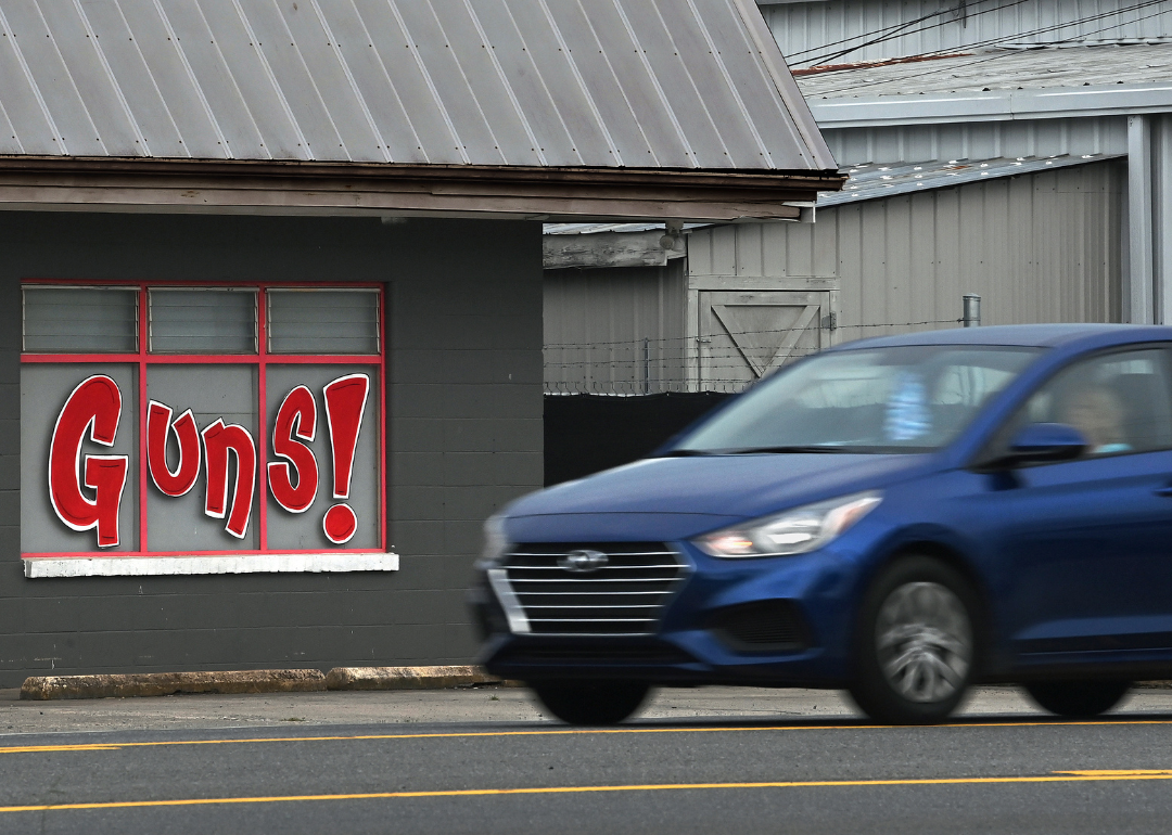 A car passing a gun store and pawn shop in Adairsville.