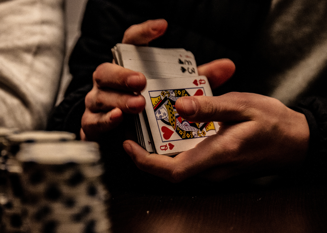 A person shuffling playing cards.