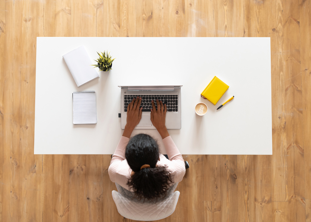 An aerial view of a person sitting at an organized, decluttered desk.