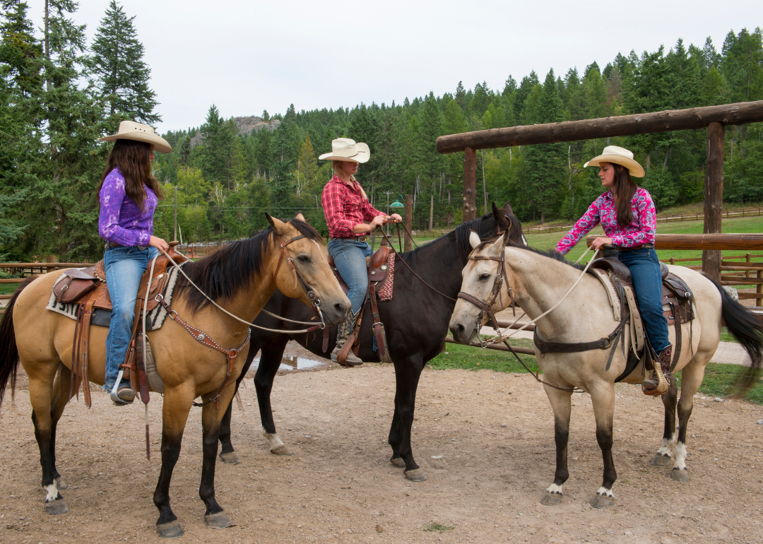 People riding horses at Averill's Flathead Lake Lodge, a dude ranch near Kalispell, Montana.