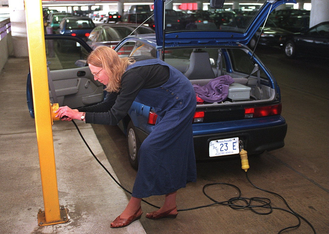 Kristina Curtis of Acton plugging in her electric powered car, a Geo Metro, in at the Alewife T station in Boston.