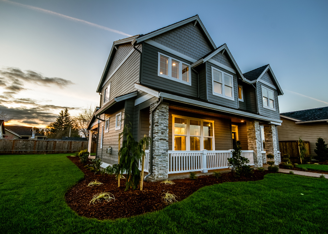A modern home with its porch lit at sunset in Oregon.