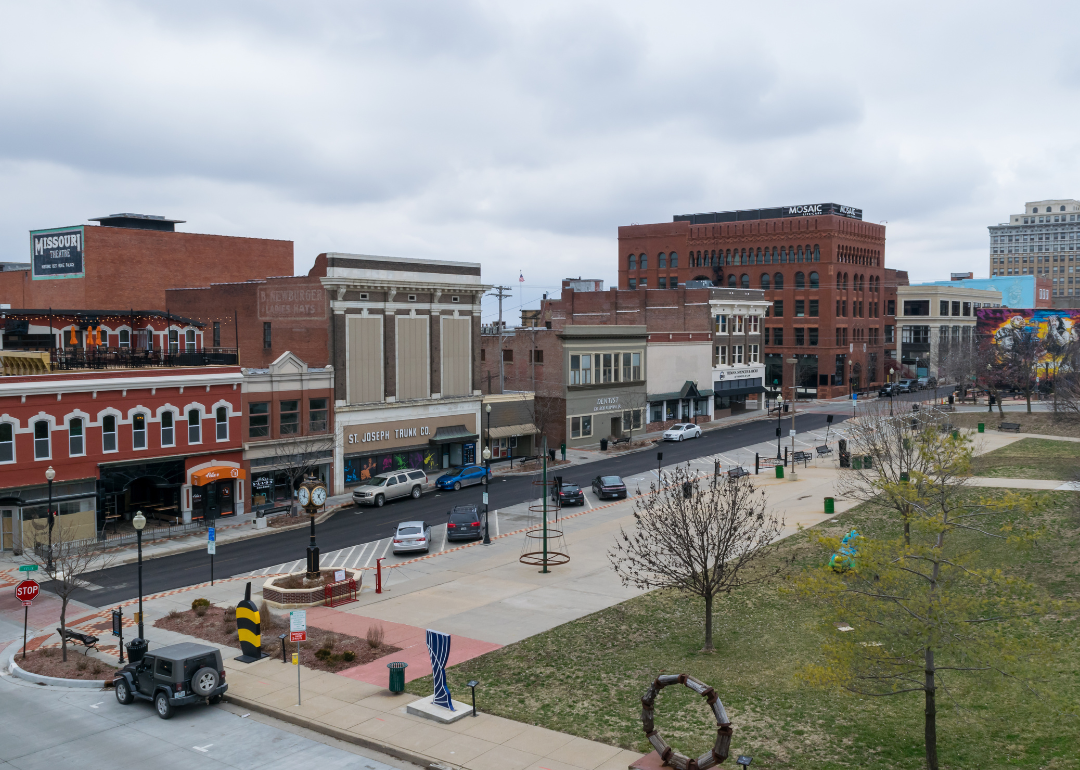 Parked cars, sculptures, and local businesses at Felix Street Square in downtown St. Joseph.