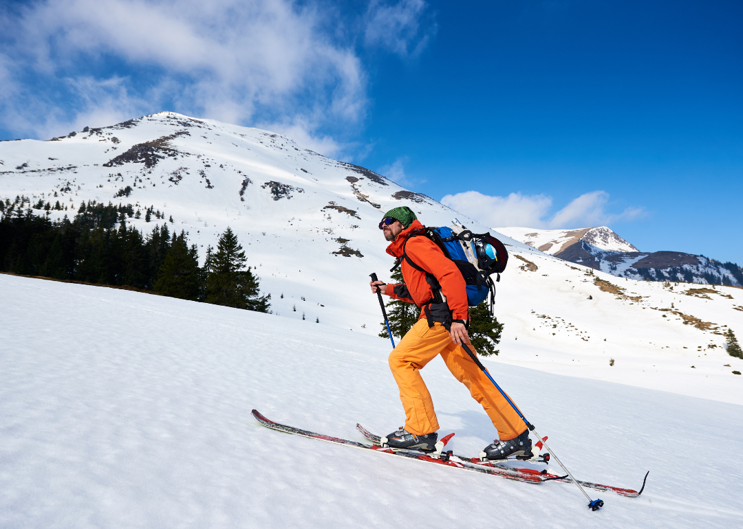 A man cross-country skiing uphill