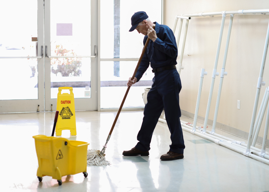 A janitor cleaning the floor of an office building.
