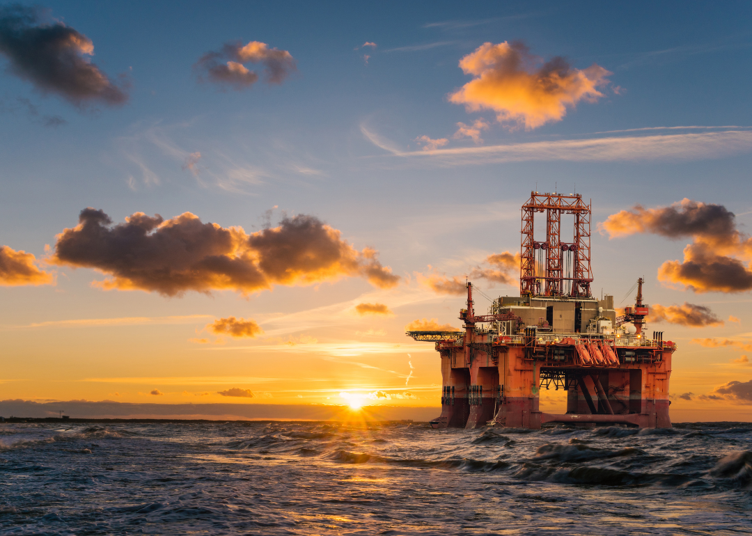 An offshore oil rig at sunset.