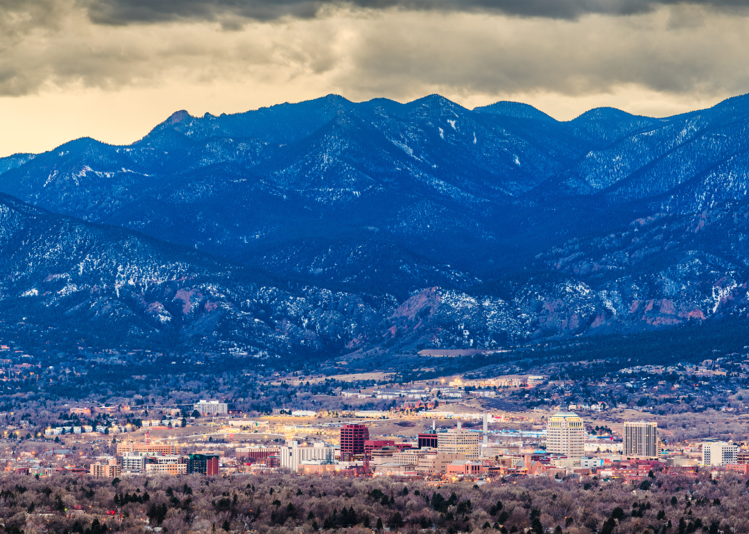 An aerial view of Colorado Springs with mountains in the background.