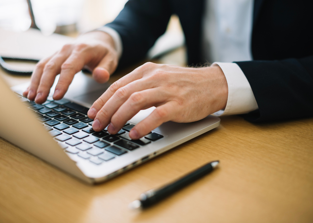 A person's hands typing on a laptop.