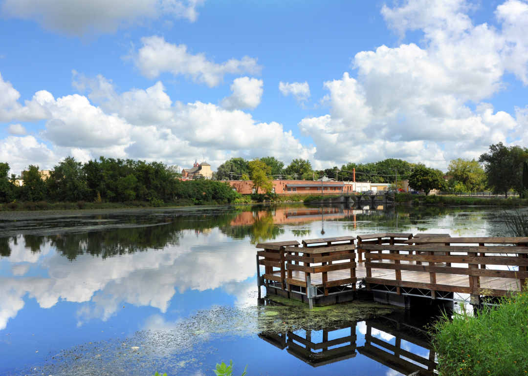 Fishing dock and blue sky is reflected in the the Yahara River.