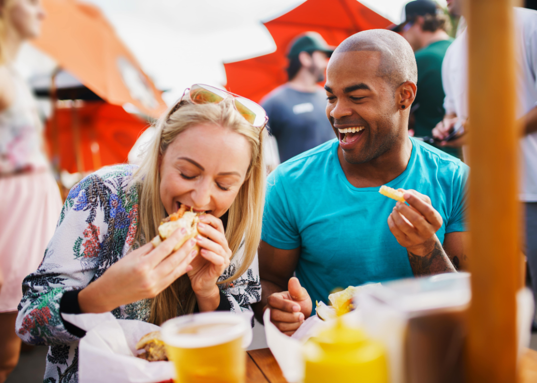 A couple laughing and eating.