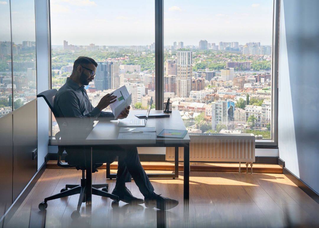 An investment banker reviewing papers in their city office.