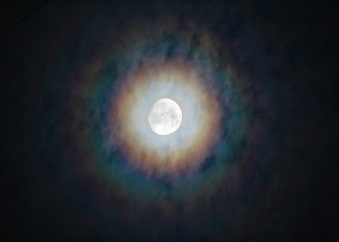 A rainbow around the moon at night.