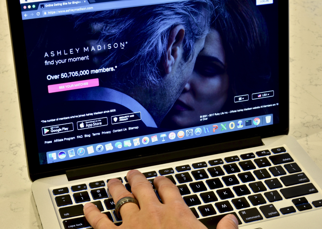 An Apple Macbook Pro displaying the Ashley Madison website while a married person browses.