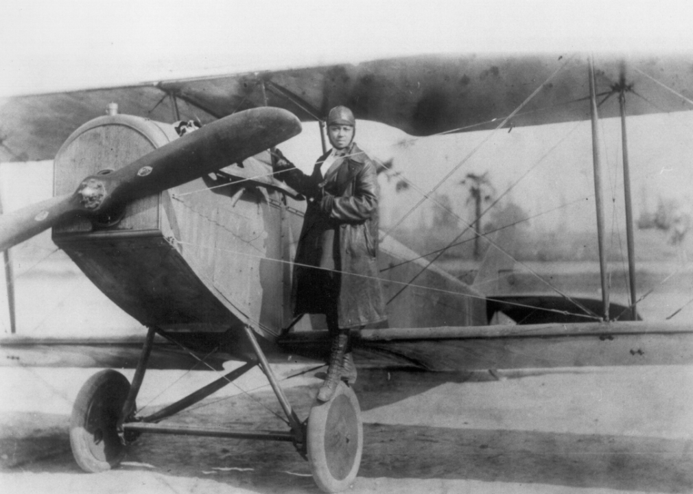 Bessie Coleman poses with her bi-plane.