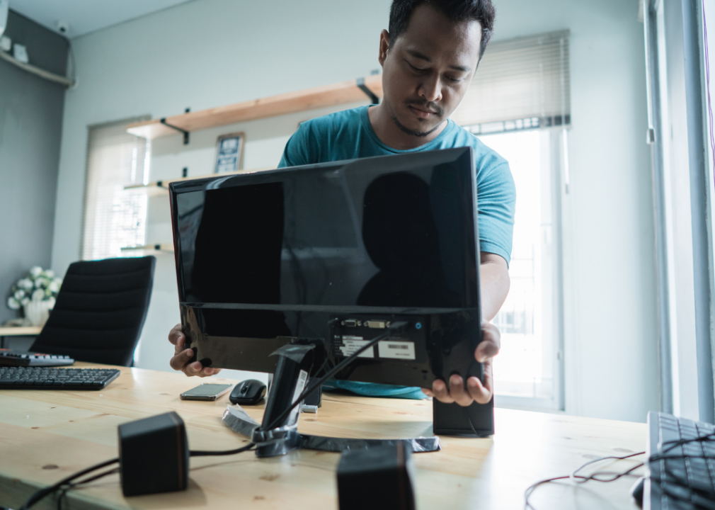 A new employee installing a monitor into their home office