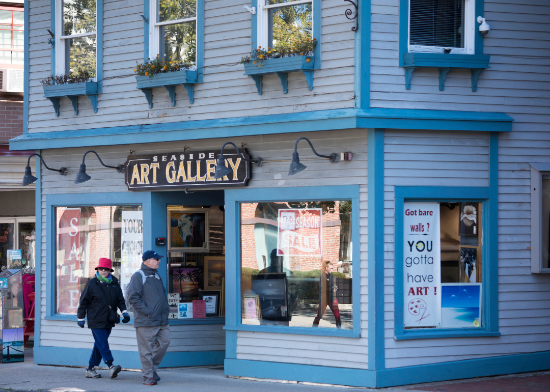 People strolling past the Seaside Art Gallery in a typical street scene in Newport, Rhode Island.