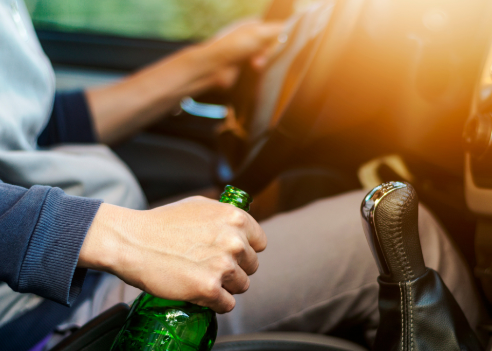 A man holding a beer while driving