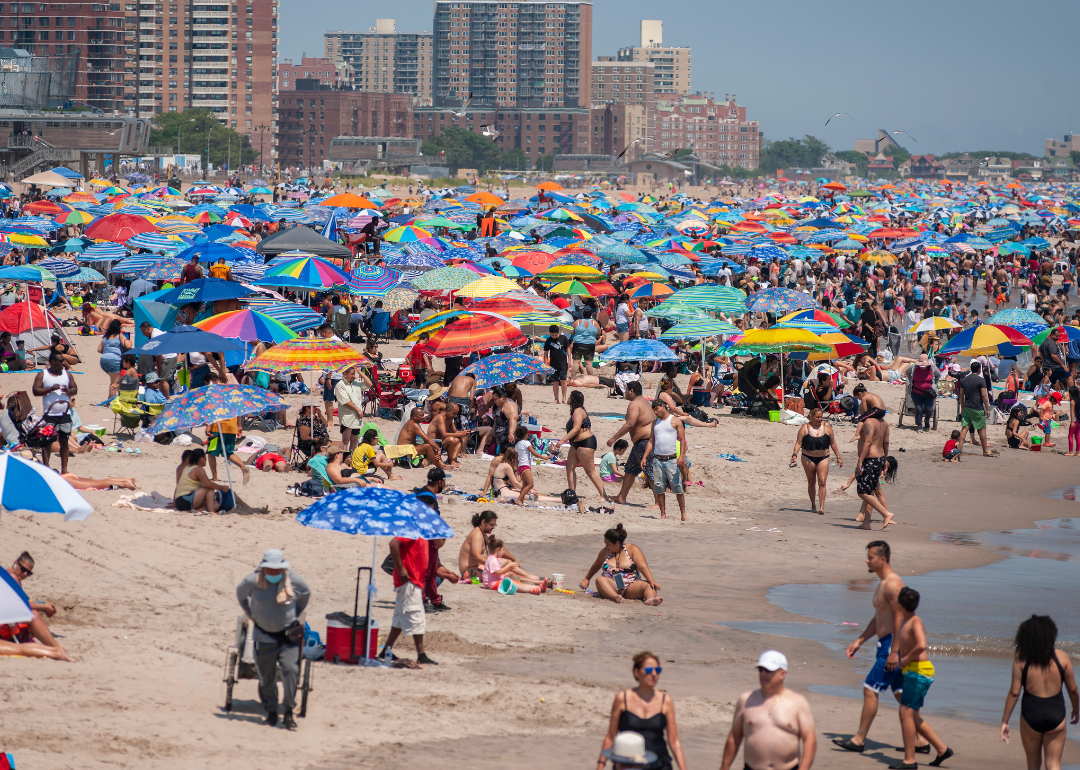 Thousands of beachgoers flocking to Coney Island on a hot summer day.
