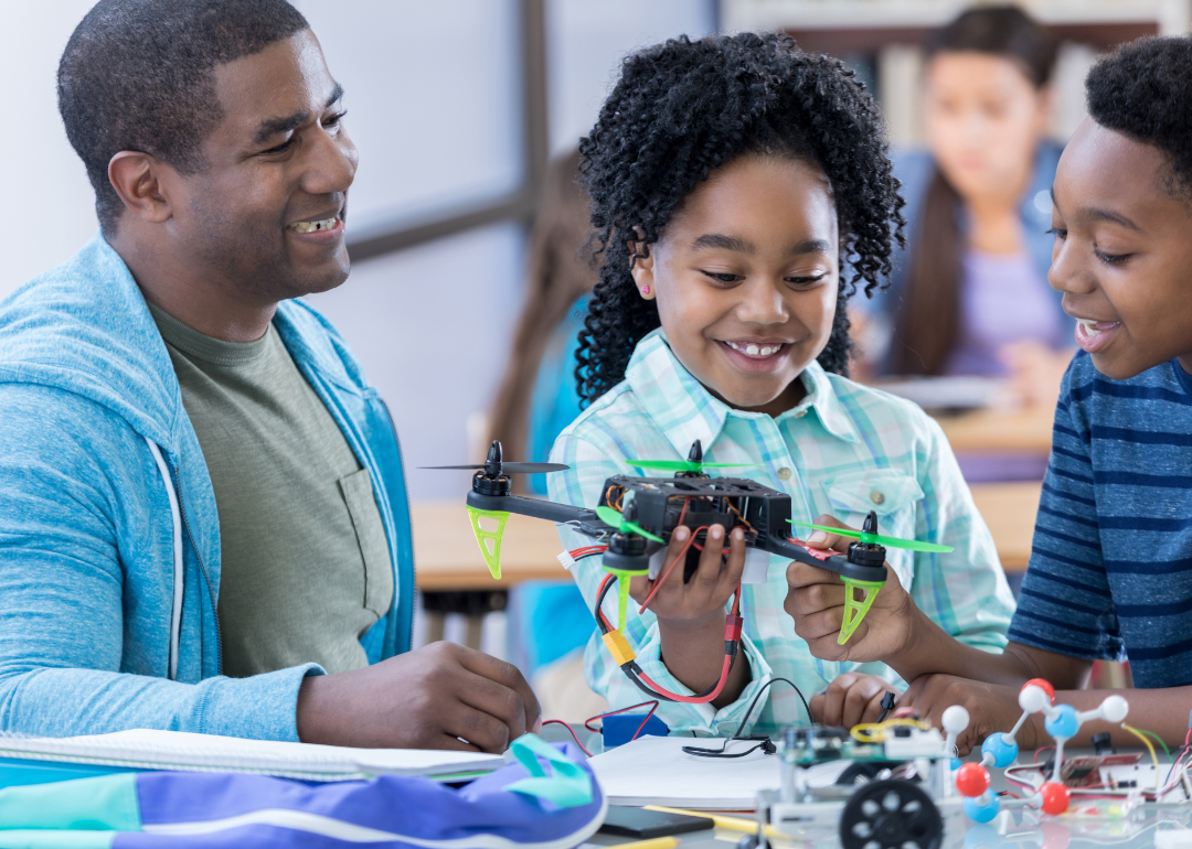 Middle school students and their teacher building a drone.