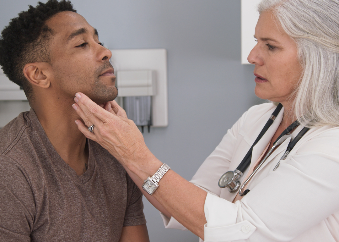 A doctor feeling a patient's lymph nodes in their neck.