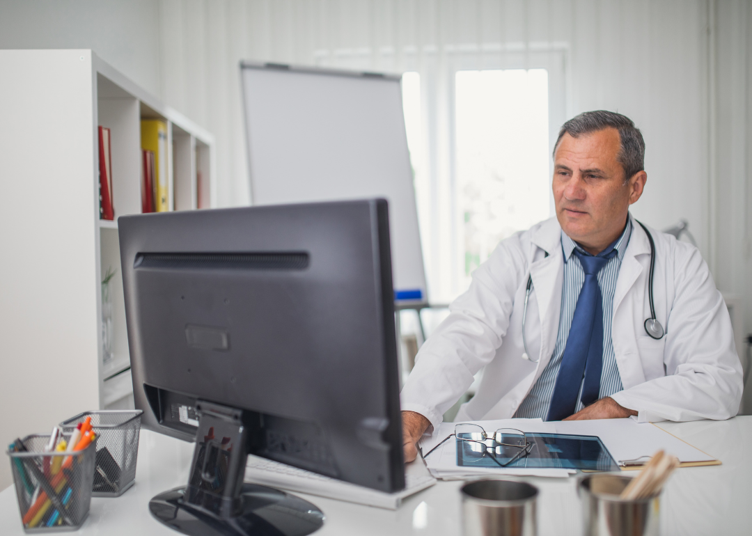 A doctor using a computer in his office.