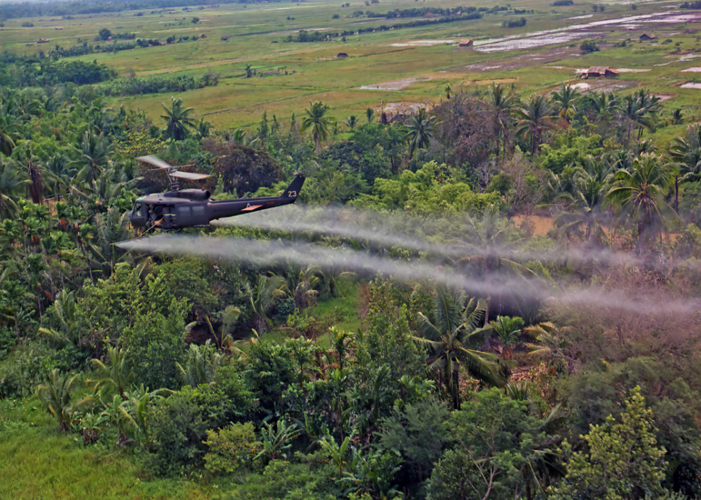 A UH-1D helicopter from the 336th Aviation Company spraying Agent Orange on a dense jungle area in the Mekong Delta.