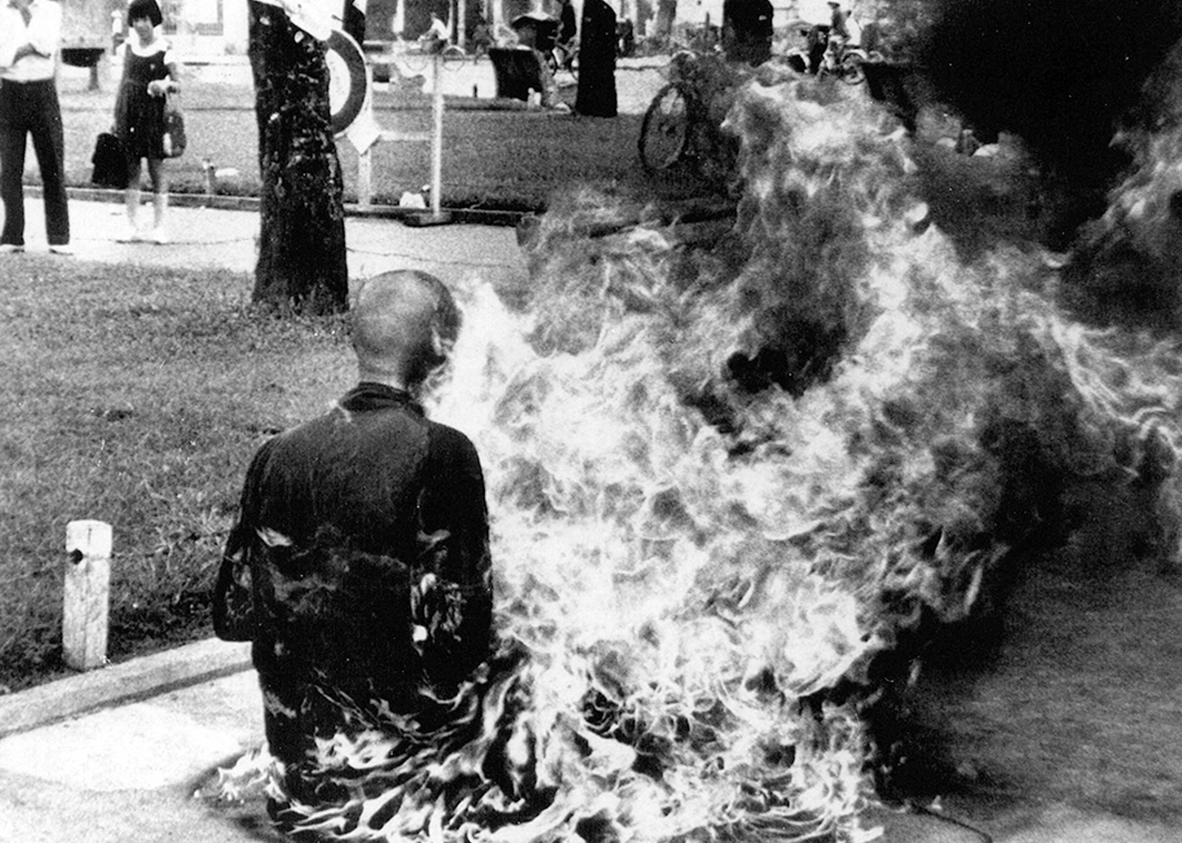 A rear view of a Buddhist monk immolating himself.