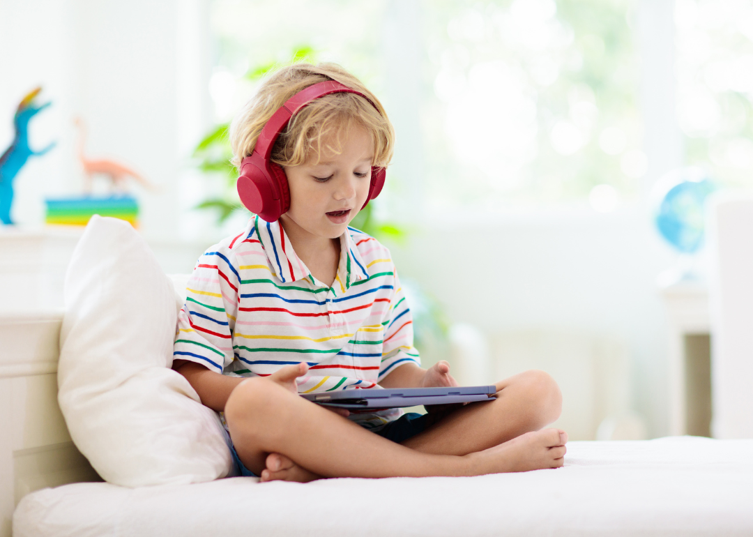 A young child playing a game on a tablet.