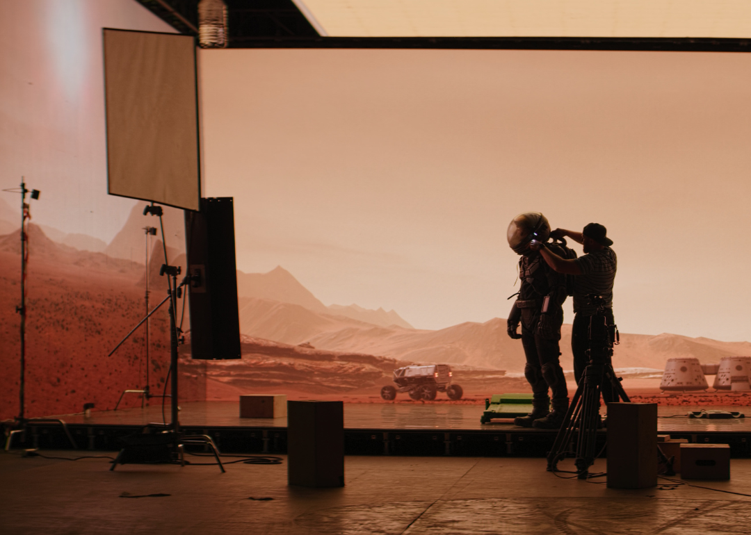 A virtual production stage with huge LED screens displaying a scene from Mars.